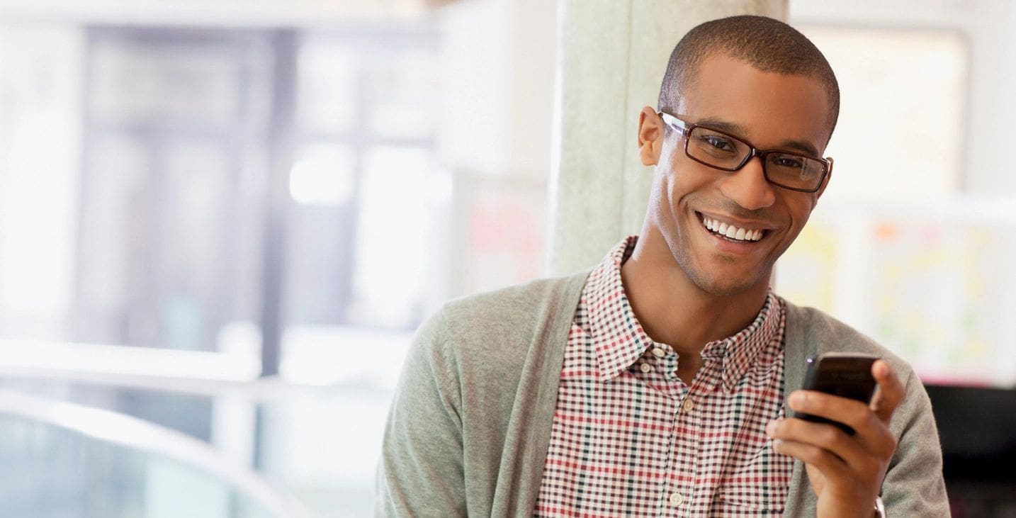 A man with glasses smiling for the camera.