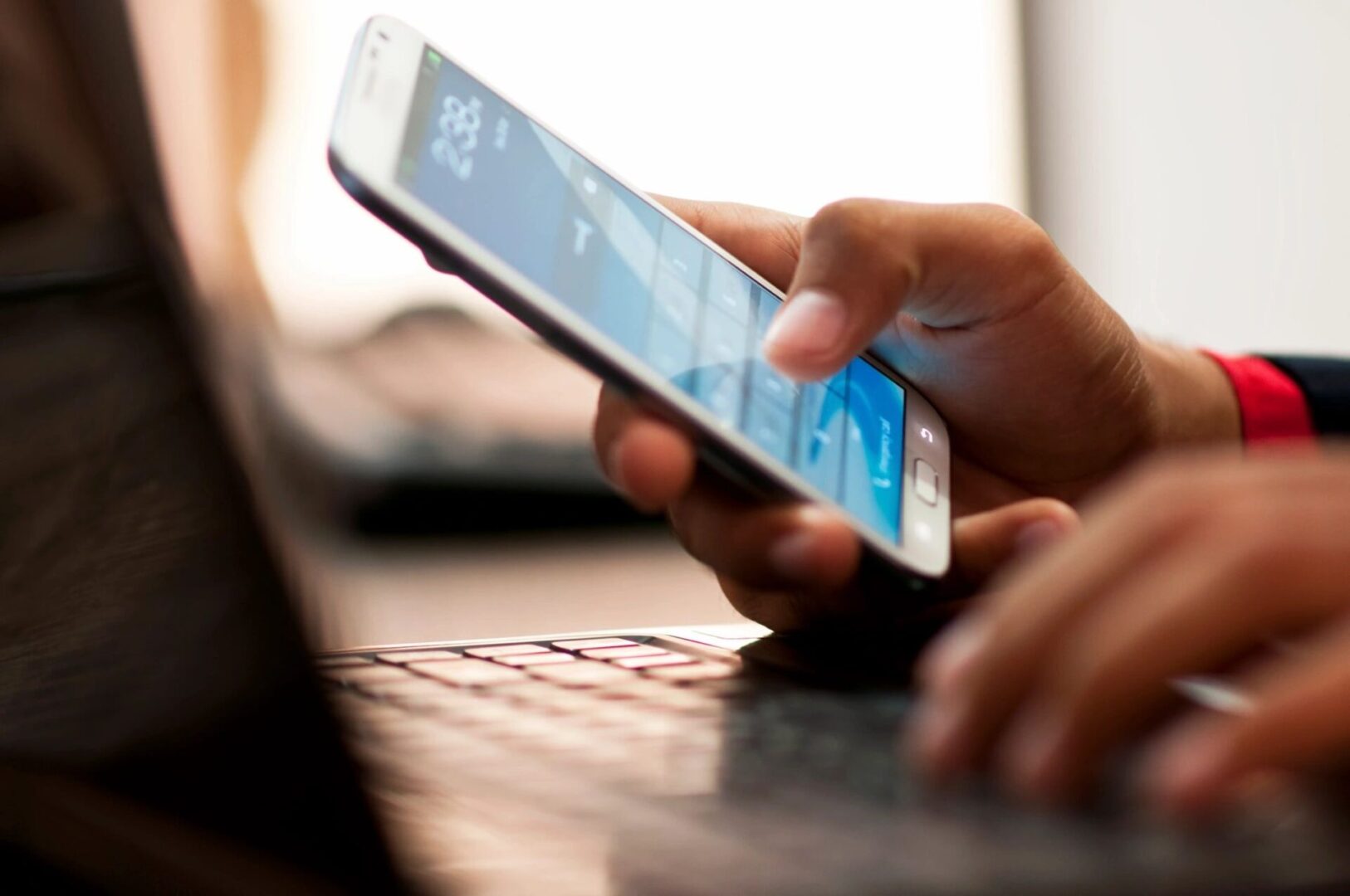 A person is using their phone while sitting at the table.